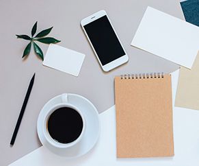 Showing Mobile phone, coffee cup and notebook